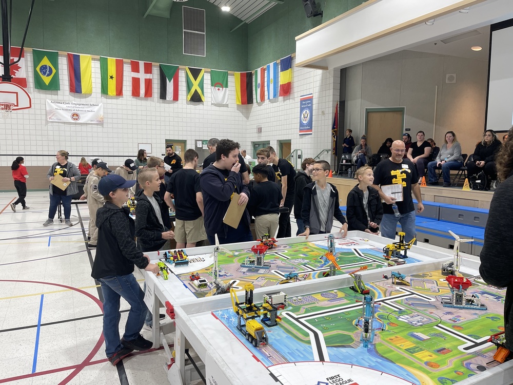 A group of people at the robotics table for FIRST Lego League.