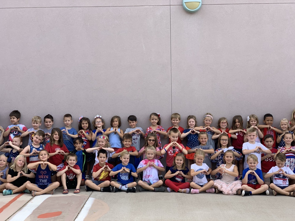 Class of students making a heart sign.