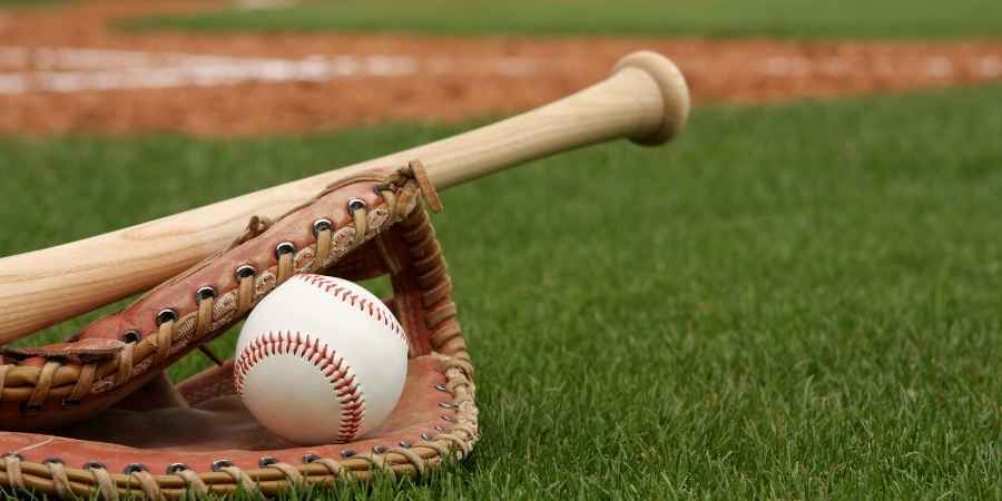 baseball bat, mitt and ball on a grassy field